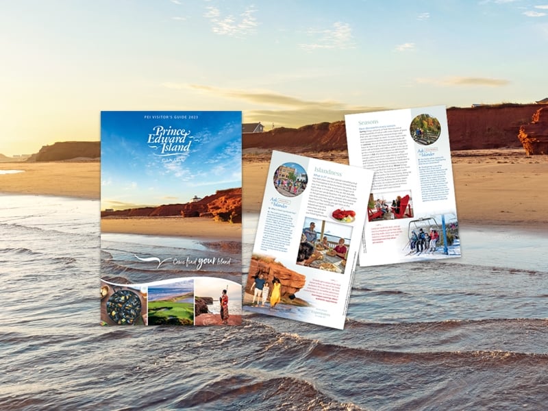 Cover image of 2023 PEI Visitor's Guide with two other inside pages pictured; image of PEI beach in background
