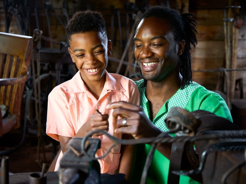 Young boy and adult learn to forge at Orwell Corner