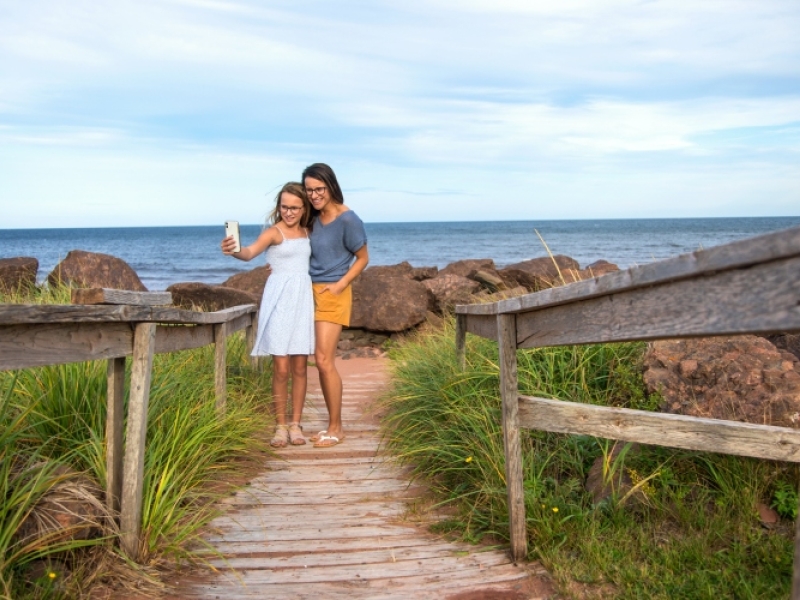 Woman and child pose for a photo on the boardwalk at Cedar Dunes Provincial Park Campground