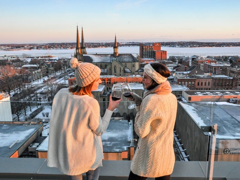 Two individuals on outdoor patio overlooking downtown Charlottetown in winter