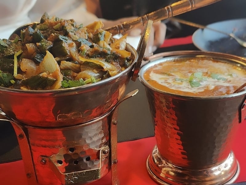 Two Indian dishes served in copper pots