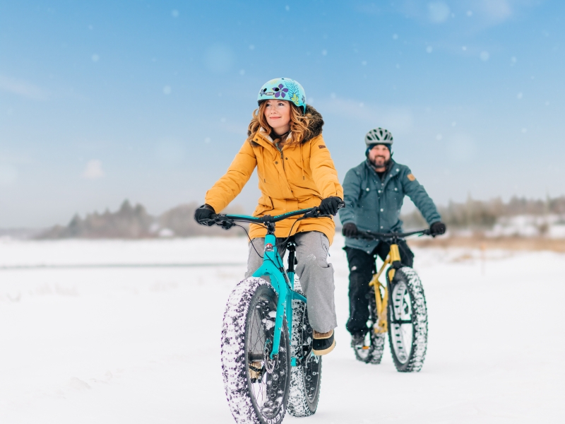 Summerside in winter, PEI Couple on fat bikes across snowy field