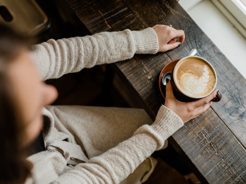 Aerial view of person at window with hot latte in hand