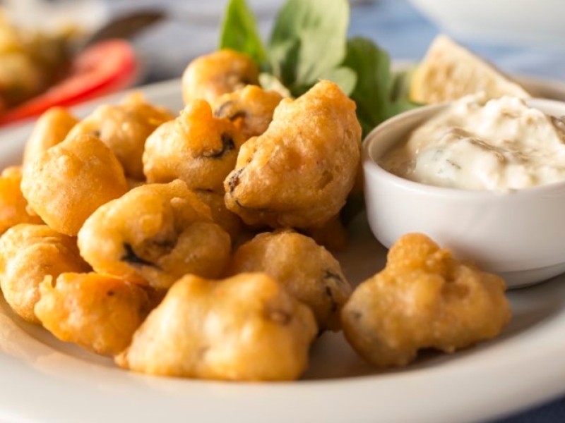 Stock image of pan fried oysters plated with dip and lettuce