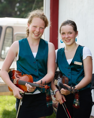 Two young girls with fiddles wait to perform at Rollo Bay Fiddle Festival