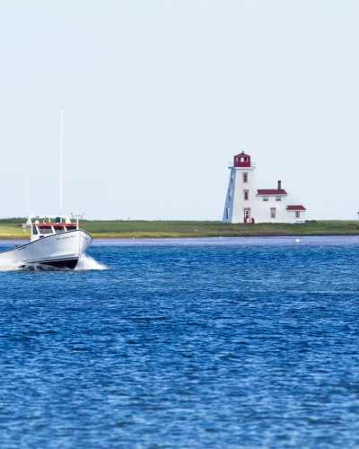 Fishing boat in Northport Harbour with Cascumpec Lighthouse in background