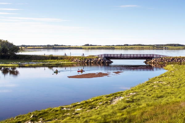 Kayers in river and cyclists on foot bridge along the Confederation Trail, Midgell, PEI