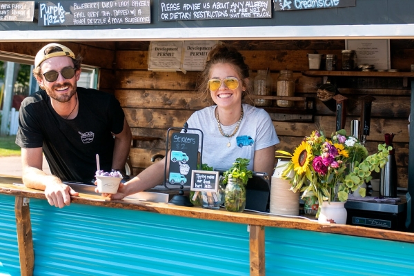 Two people serve rolled ice cream from Food Truck