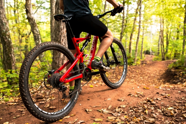 Close-up of feet on pedals of moutain bike in wooded area of Brookvale trails