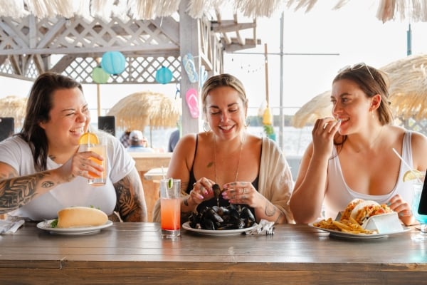 Three women eating on a patio in Summerside