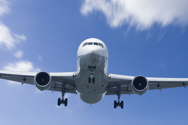 Stock image of airplane coming in for landing with Amercia flag graphics