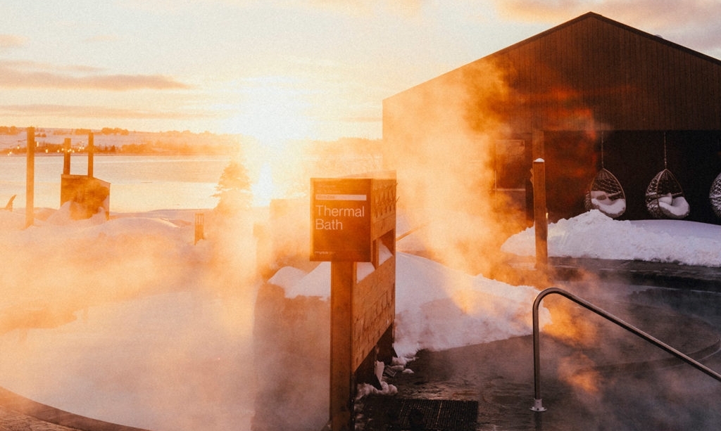 Thermal bath and steam rising outdoors at Mysa Spa with St. Peter's Bay in background